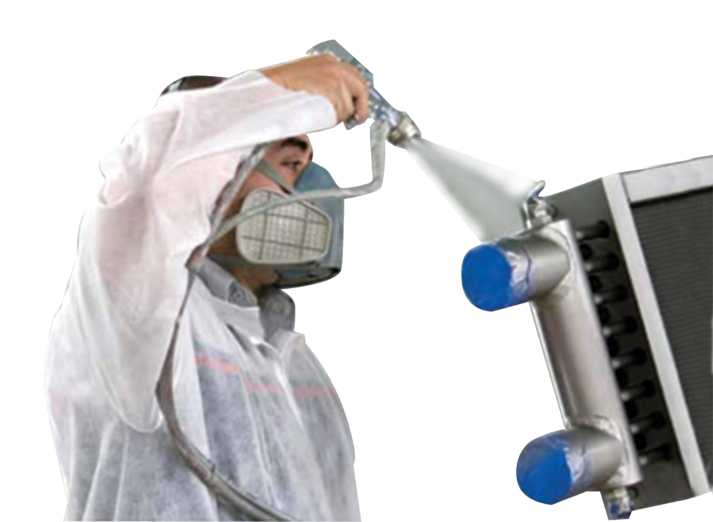 man spraying anti-corrosive spray on a heat exchanger